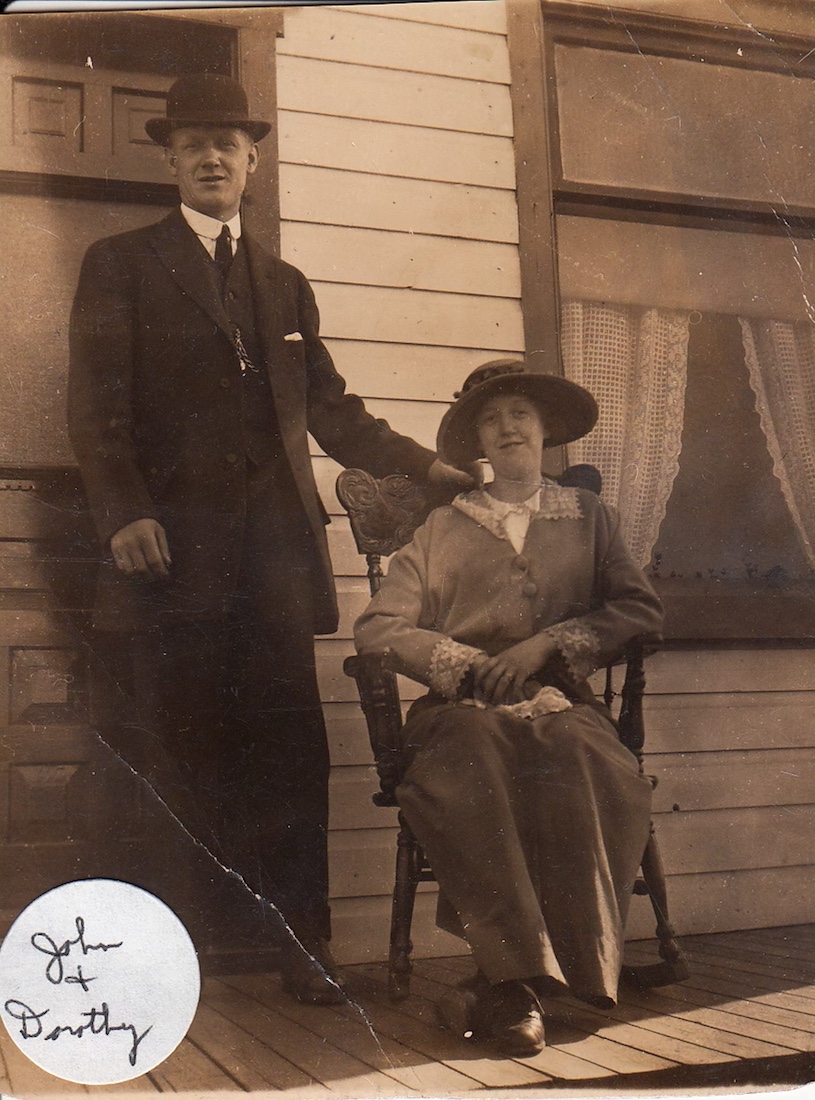Man and woman in sunday best, woman sitting, man standing