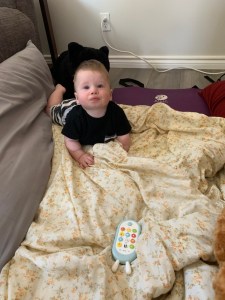 7 month old grandson playing on the floor looking at me 